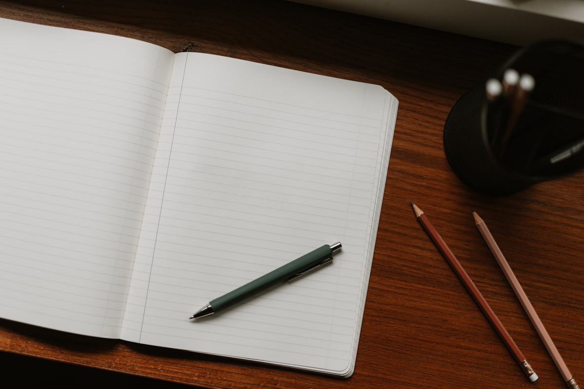 Orbita Habit Tracker — Carnet ouvert avec stylo et crayons sur bureau
